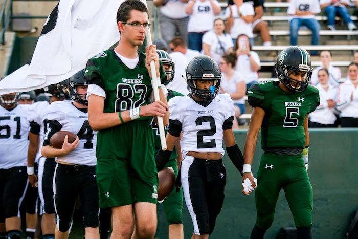 (Chris Detrick  |  The Salt Lake Tribune)    Hillcrest's Tyson Flores (5) Highland's Marion Jones (2) and other members of the football teams hold hands as they walk onto the field before the game at Hillcrest High School Friday, September 1, 2017. Cazzie Brown passed away Sunday night after spending four days in the hospital. According to a family representative, Brown was brought to the emergency room Wednesday for complications with his thyroid. The doctors found that he had contracted meningitis, and later received a preliminary positive after being tested for West Nile virus. 