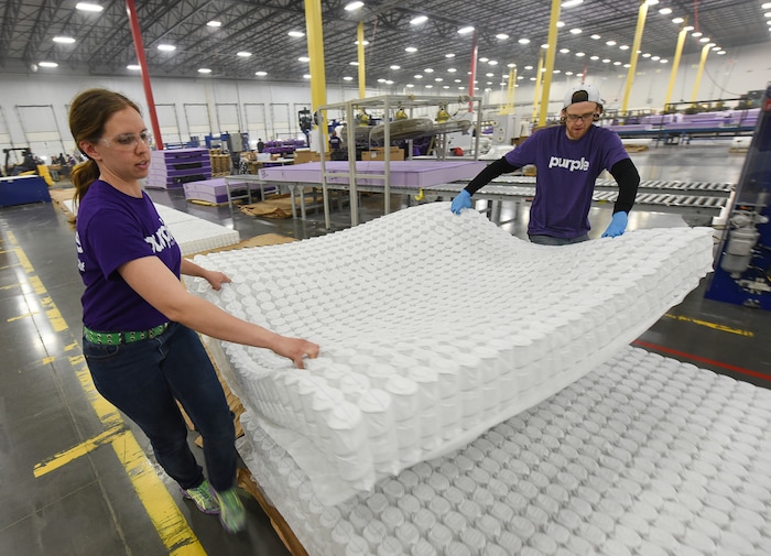 (Francisco Kjolseth | The Salt Lake Tribune)  Malia Spence and Jake Williams stack mattresses of "individual responsive support coils" that make up the core of a line of mattresses for Purple, an Alpine based company that has developed tech to manufacture flexible mattresses at a plant in Grantsville.