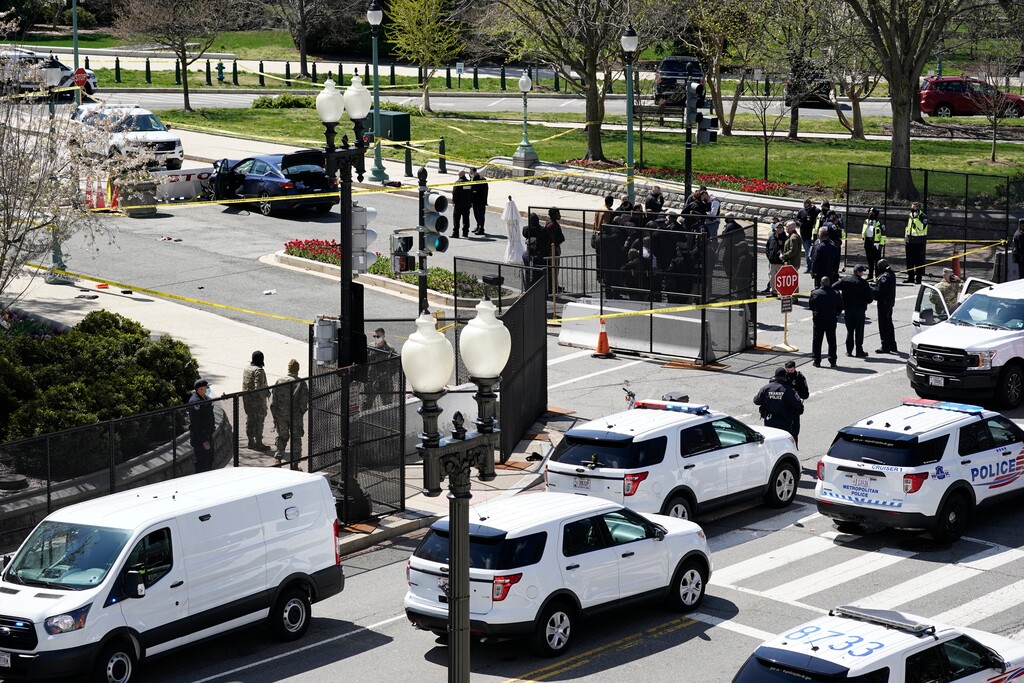 (J. Scott Applewhite | AP Photo) Police officers gather near a car that crashed into a barrier on Capitol Hill in Washington, Friday, April 2, 2021.