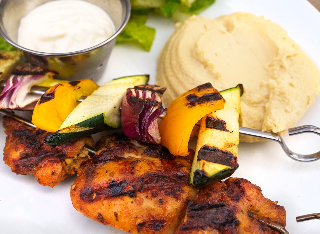 (Leah Hogsten | The Salt Lake Tribune) Emigration Cafe's Chicken Shawarma Skewer with green garbanzo hummus, red onion, zucchini, garlic yogurt sauce served with house pita, $18, April 27, 2022. Emigration Cafe's menu features Roman style wood fired pizza, salads, sandwiches and mains.