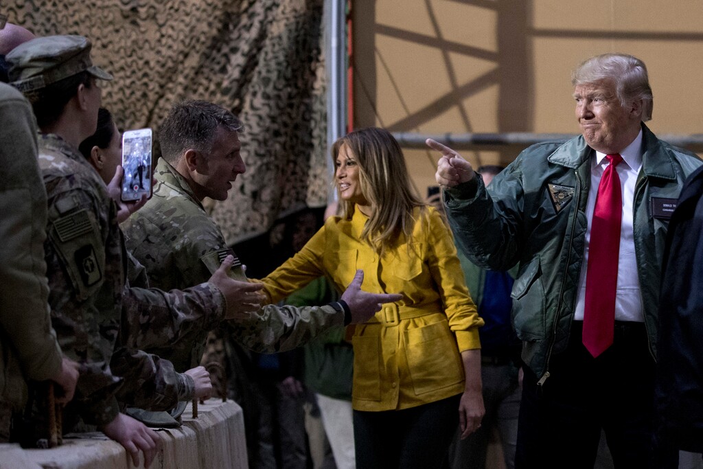 (Andrew Harnik | The Associated Press) President Donald Trump and first lady Melania Trump greet members of the military as they arrive for a hanger rally at Al Asad Air Base, Iraq, Wednesday, Dec. 26, 2018. In a surprise trip to Iraq, President Donald Trump on Wednesday defended his decision to withdraw U.S. forces from Syria where they have been helping battle Islamic State militants.