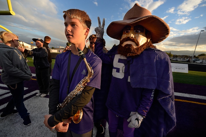 (Scott Sommerdorf   |  The Salt Lake Tribune)   Lehi saxophonist Gavin Clifton is visited by "Pete the Pioneer" prior to kickoff between Olympus and Lehi. With Gavin and Pete's help, Lehi beat Olympus 33-3, Friday, September 22, 2017.