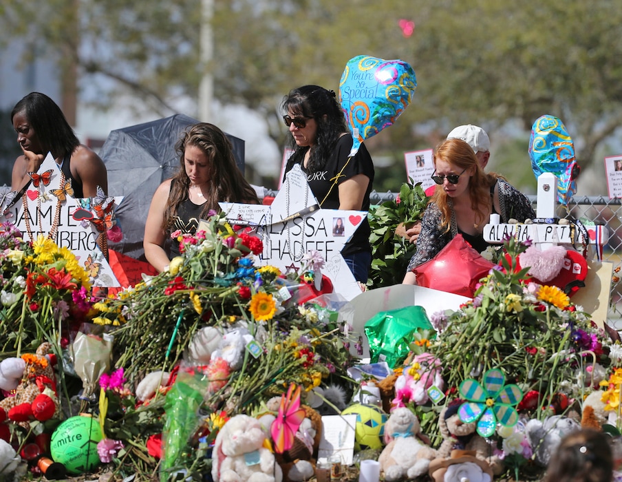 (David Santiago | Miami Herald via AP, File) In this Feb. 25, 2018 file photo, mourners bring flowers as they pay tribute at a memorial for the victims of the shooting at Marjory Stoneman Douglas High School, in Parkland, Fla. The community of Parkland, Florida, is focusing on suicide prevention programs after two survivors of the Florida high school massacre there killed themselves this month. Parkland Mayor Christine Hunschofsky said Monday, March 25, 2019, that officials are publicizing the available counseling services after a second Marjory Stoneman Douglas High School student apparently killed himself over the weekend.