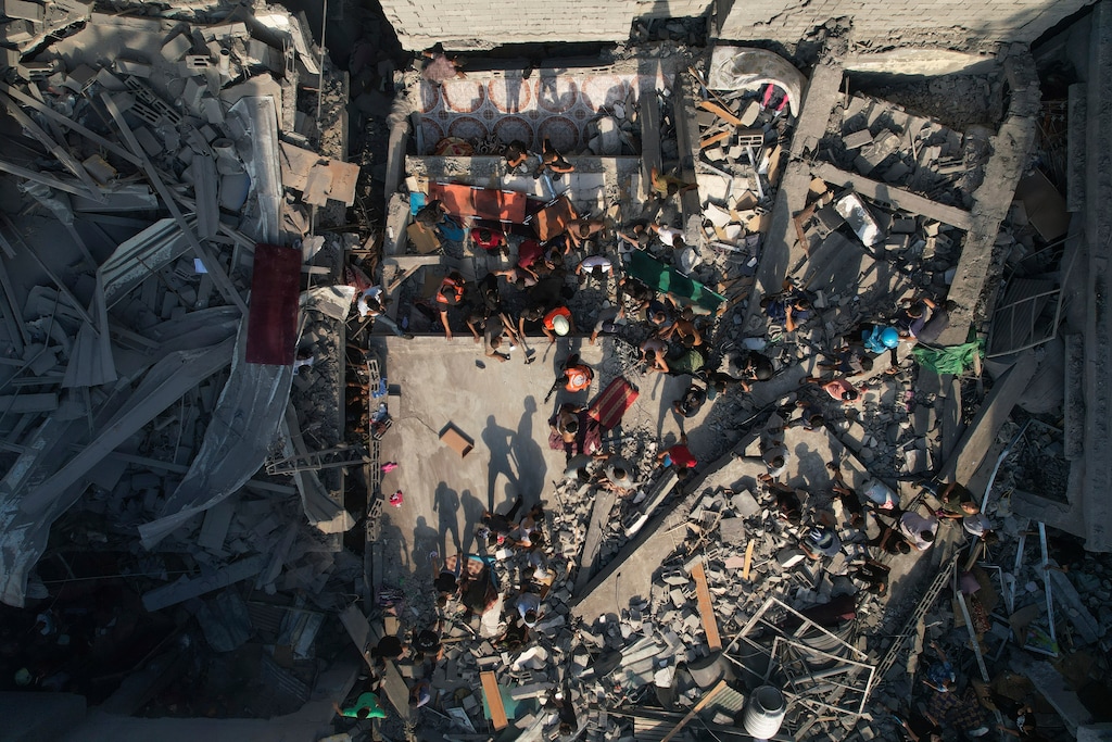 (Hatem Moussa | The Associated Press) Palestinians inspect the rubble of buildings hit by an Israeli airstrike at Al Shati Refugee Camp Thursday, Oct. 12, 2023. Israel's retaliation has escalated after Gaza's militant Hamas rulers launched an unprecedented attack on Israel Saturday, killing over 1,200 Israelis and taking captive dozens. Heavy Israeli airstrikes on the enclave has killed over 1,200 Palestinians.