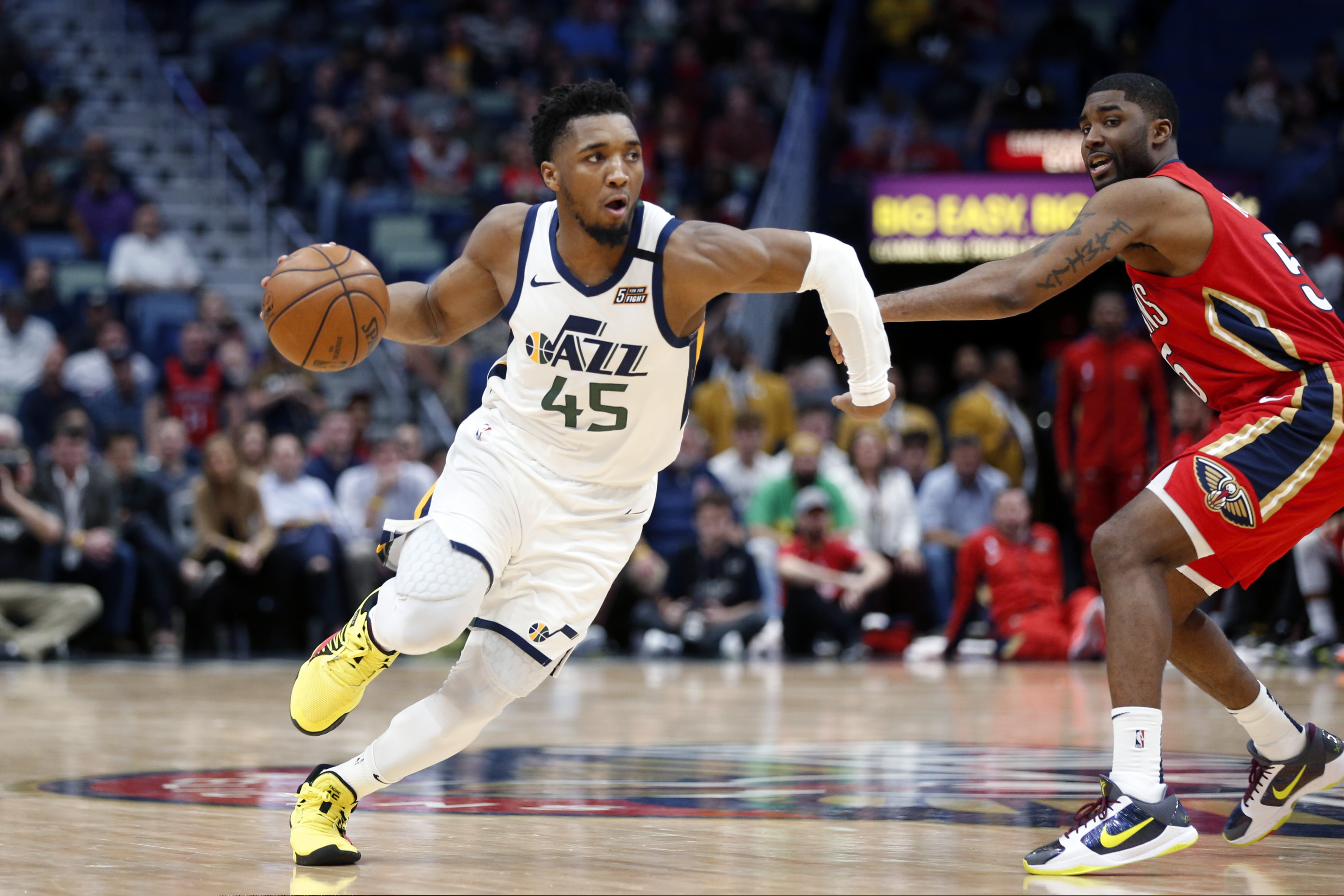 Utah Jazz guard Donovan Mitchell (45) drives to the basket as New Orleans Pelicans guard E'Twaun Moore defends during overtime of an NBA basketball game in New Orleans, Thursday, Jan. 16, 2020. The Pelicans won 138-132. (AP Photo/Gerald Herbert)