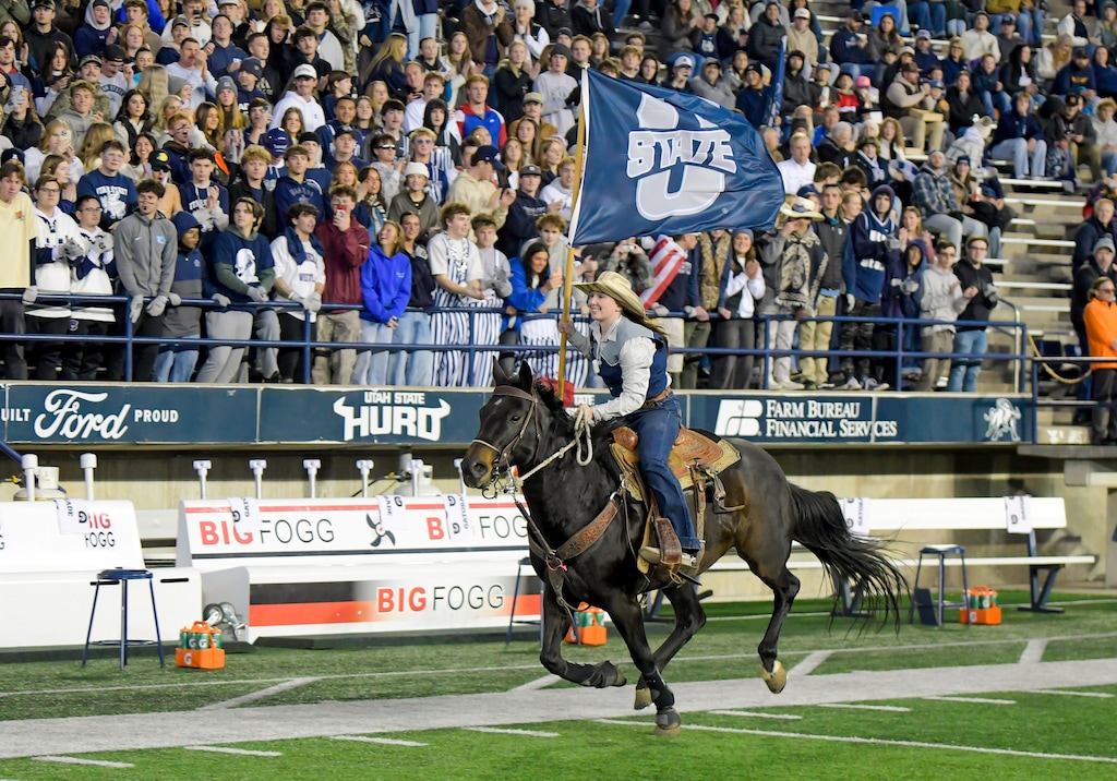 (Eli Lucero | Herald Journal) A member of the school's rodeo team carries a flag around Maverik Stadium before Utah State plays Nevada on Saturday, Nov. 8, 2025, in Logan.