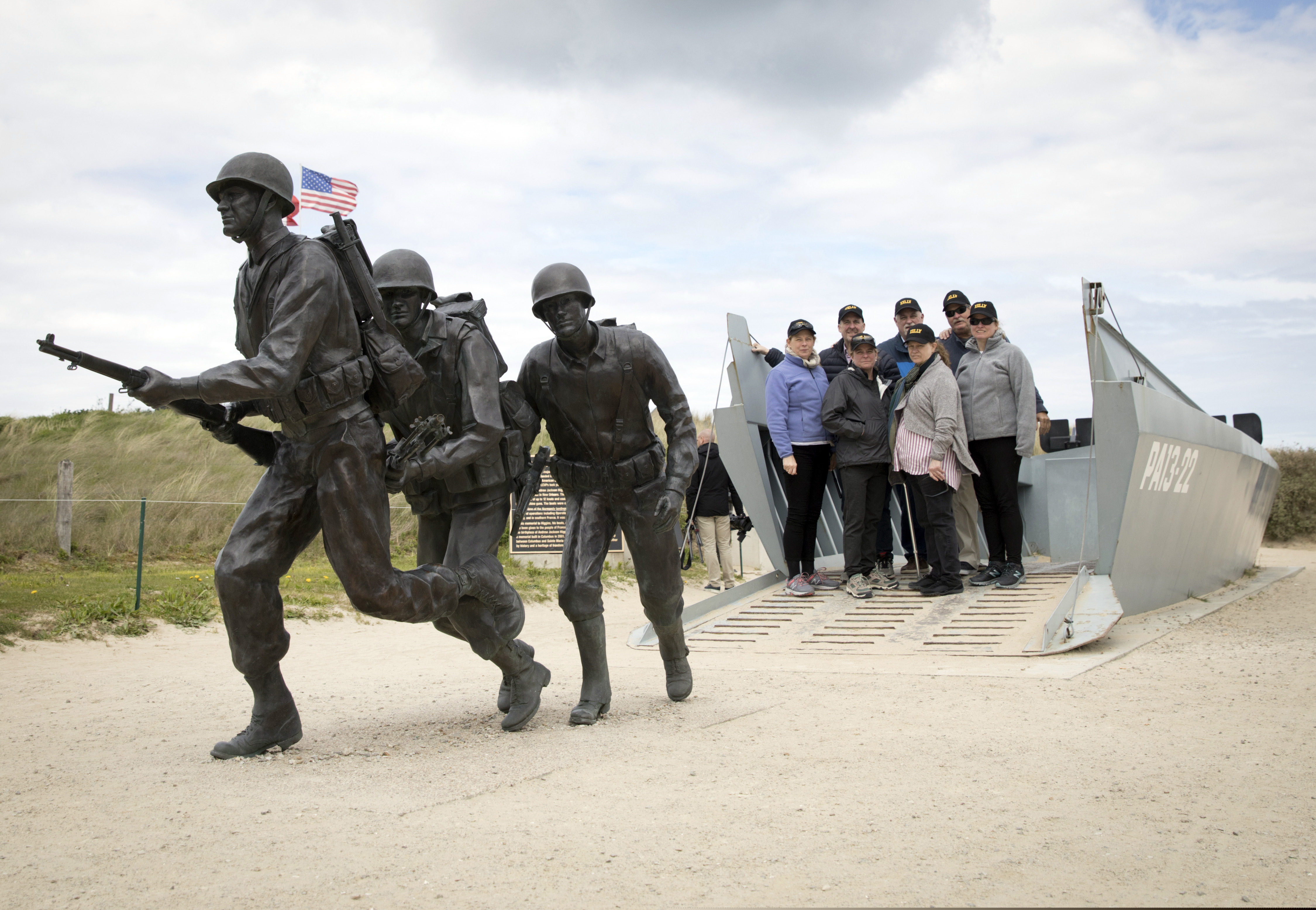 In this May 2, 2019, photo, people stand in a replica landing craft near a statue of WWII U.S. soldiers on Utah Beach in Sainte-Marie-du-Mont, Normandy, France. With fewer veterans and witnesses able to share personal stories and memories, the French who owe their freedom to D-Day’s fighters are more determined than ever to keep alive the memory of the battle and its significance. (AP Photo/Virginia Mayo)