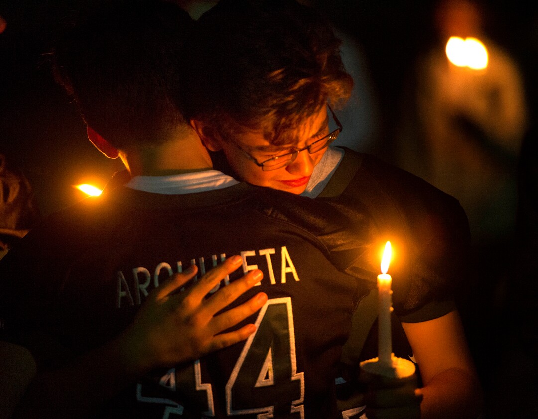 (Rick Egan  |  The Salt Lake Tribune)Members of the Hillcrest football team comfort each other during a candlelight vigil in honor of coach Cazzie Brown, at Hillcrest High School, Monday, August 28, 2017.
