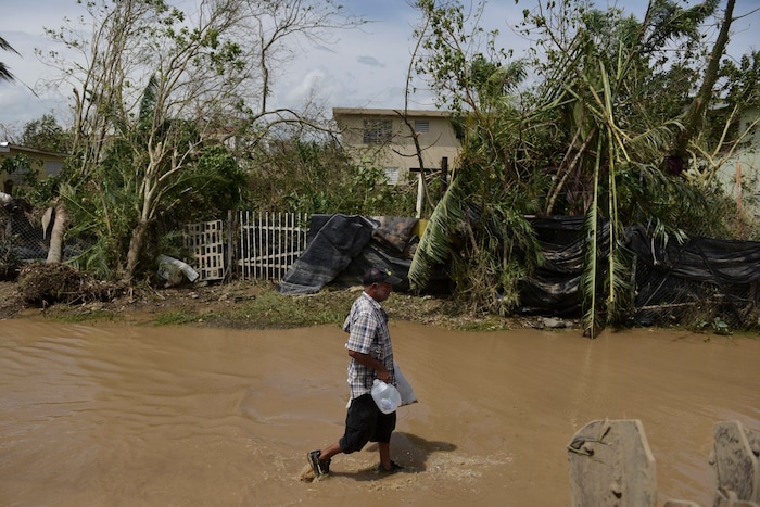 A resident walks on a flooded road after the passing of Hurricane Maria, in Toa Baja, Puerto Rico, Friday, September 22, 2017. Because of the heavy rains brought by Maria, thousands of people were evacuated from Toa Baja after the municipal government opened the gates of the Rio La Plata Dam. (AP Photo/Carlos Giusti)