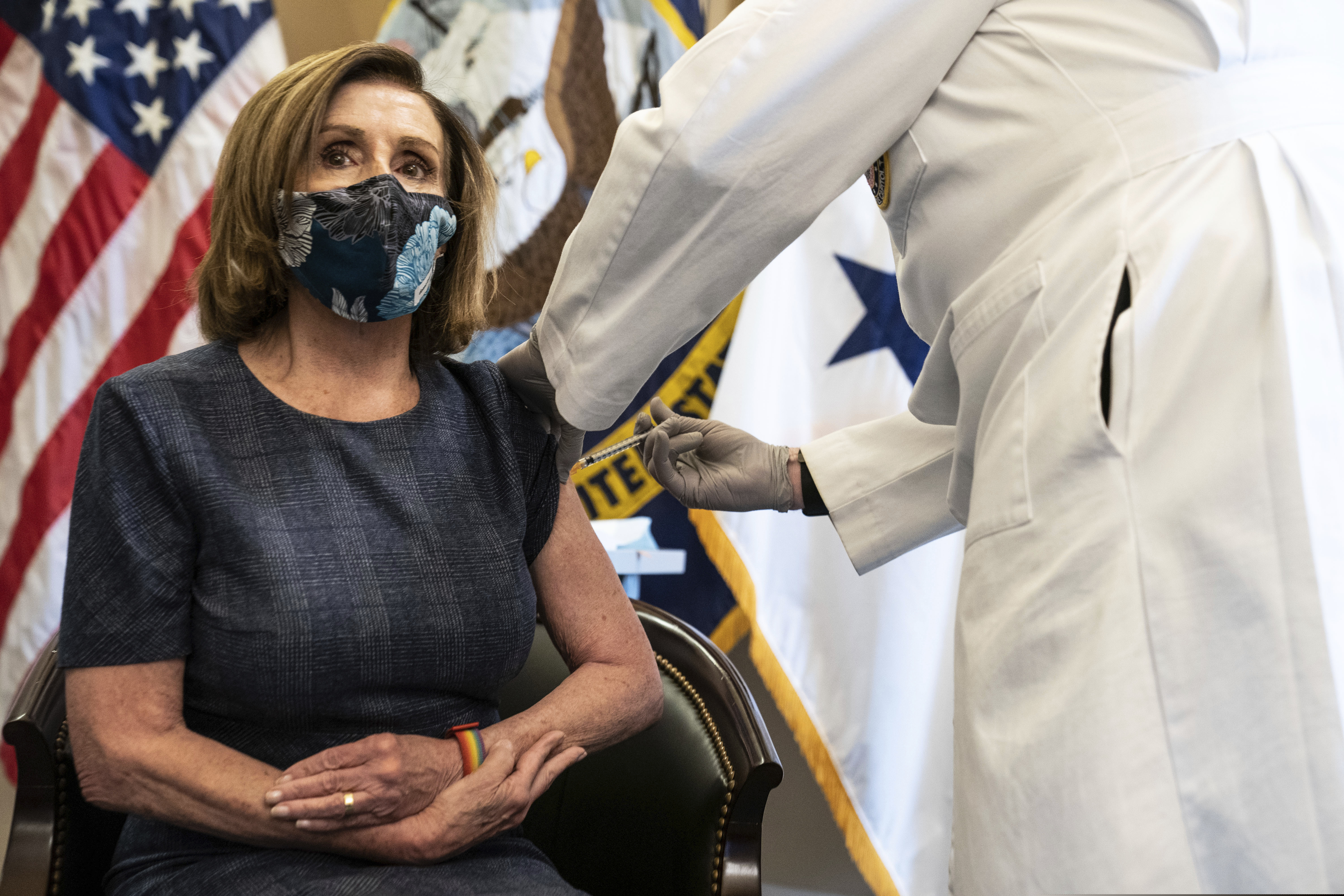 (Anna Moneymaker | The New York Times via AP, Pool) Speaker of the House Nancy Pelosi, D-Calif., receives a Pfizer-BioNTech COVID-19 vaccine shot by Dr. Brian Monahan, attending physician Congress of the United States in Washington, Friday, Dec. 18, 2020.