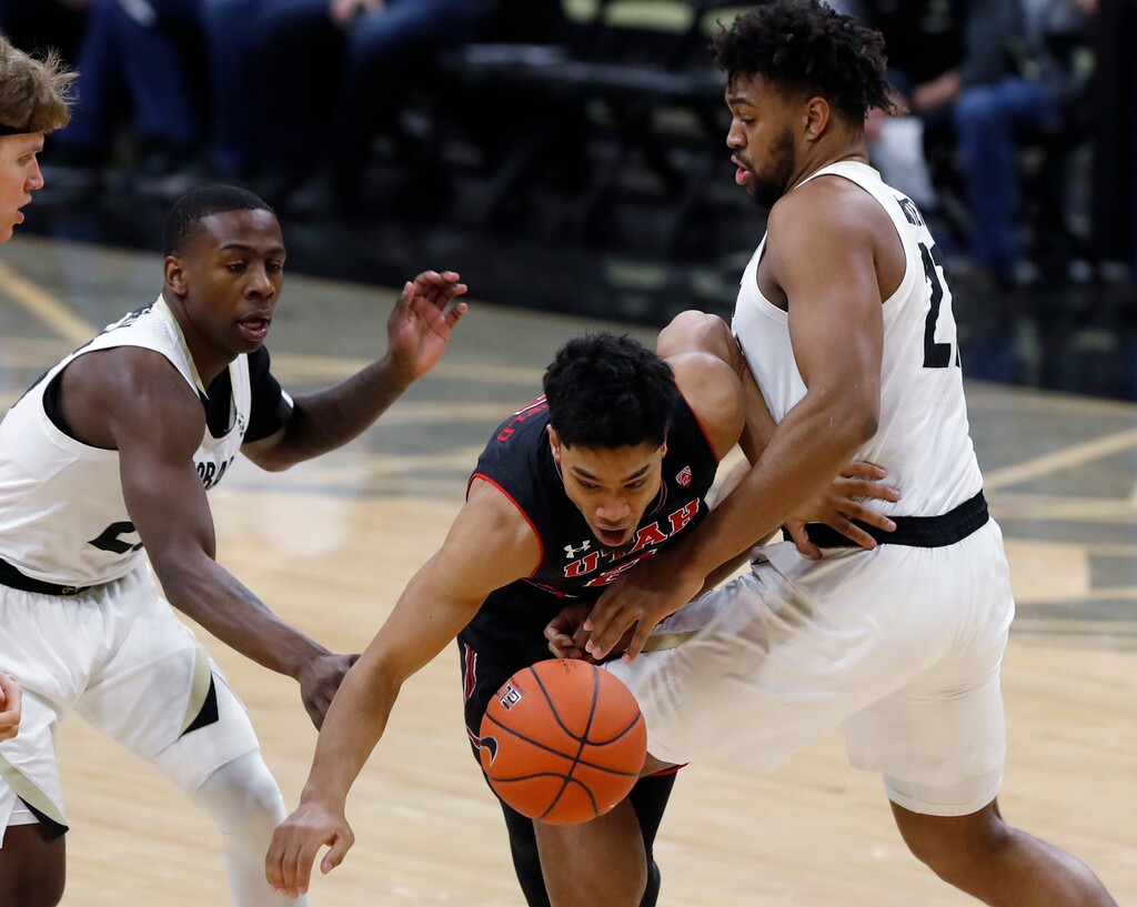 (David Zalubowski | The Associated Press) Utah guard Sedrick Barefield, center, is fouled by Colorado forward Evan Battey, right, while driving the lane past guard McKinley Wright IV during the first half of an NCAA college basketball game Saturday, March 2, 2019, in Boulder, Colo.