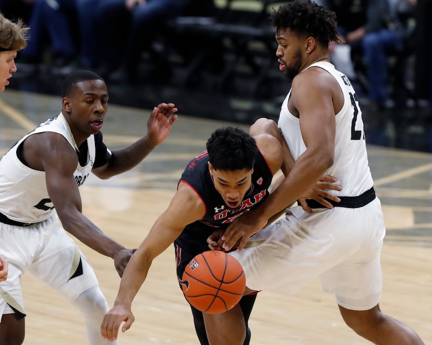 (David Zalubowski | The Associated Press) Utah guard Sedrick Barefield, center, is fouled by Colorado forward Evan Battey, right, while driving the lane past guard McKinley Wright IV during the first half of an NCAA college basketball game Saturday, March 2, 2019, in Boulder, Colo.