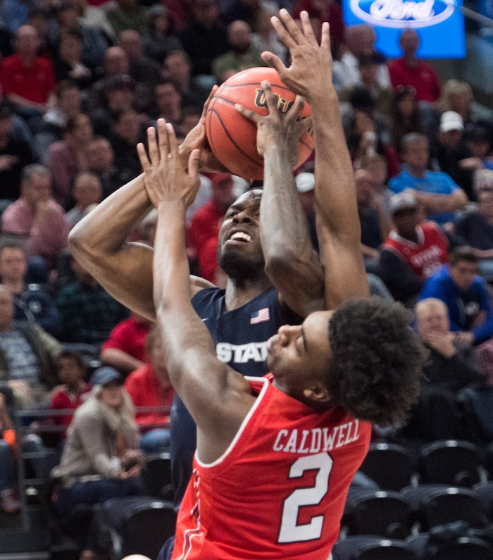 (Rick Egan  |  The Salt Lake Tribune) Utah State Aggies guard DeAngelo Isby (0) shoots, as Utah Utes guard Kolbe Caldwell (2) defends, in Beehive Classic basketball action at the Vivint SmartHome Arena, Saturday, December 9, 2017.