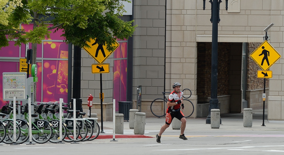 (Francisco Kjolseth  |  The Salt Lake Tribune)  Salt Lake Tribune reporter Ben Wood runs the last leg of his race against colleagues during a downtown transportation race from Library Square to the Tribune building at the Gateway on Thursday, Aug. 2, 2018, after docking his Green Bike. Modes of transportation included, rentable electric scooters, Green Bike, TRAX, Lyft, and walking.