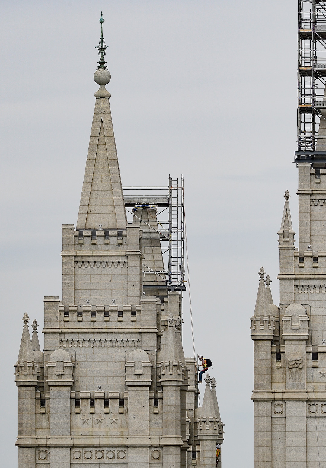 (Francisco Kjolseth  |  The Salt Lake Tribune) A crew member descends an adjacent spire as crews work to remove the Angel Moroni statue atop the Salt Lake Temple of The Church of Jesus Christ of Latter-day Saints on Monday, May 18, 2020. The temple closed in December for seismic upgrades and sustained minor damager during the March 18, 2020, magnitude 5.7 earthquake when the trumpet held by the angel fell off and several smaller spire stones were displaced.
