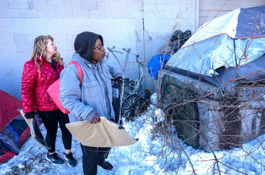 (Rick Egan | The Salt Lake Tribune) Carin Crowe, from Habitat for Humanity, and Ty Bellamy with Black Lives for Humanity, distribute wool blankets donated by the Sikh community to people in camps in Salt Lake City to help the unsheltered stay warm Thursday, Dec. 23, 2021.