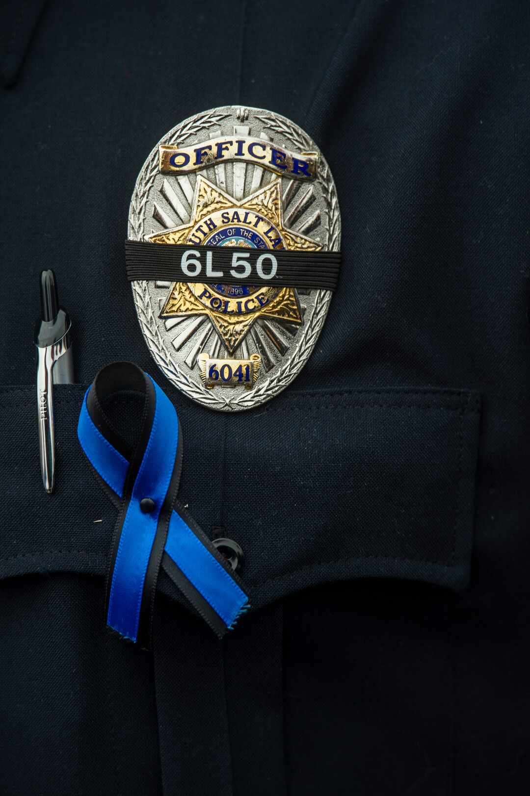 South Salt Lake Police officers were black band over their badges, during the funeral for South Salt Lake police officer, David Romrell, at the Maverik Center, in West Valley City, Wednesday, Dec. 5, 2018.