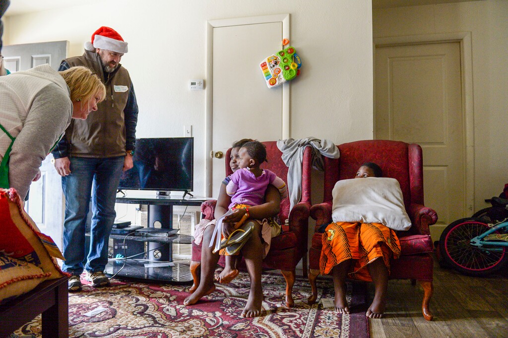 (Leah Hogsten | The Salt Lake Tribune) Sepheni Ninahazina, 10, and her two sisters Christo,1, and Fide, 6, greet Linda Baugh, her husband Dave Baugh and their extended family at the Ninahazina home. The Baughs, all volunteers with Shalom Salaam Tikkun-Olam, a local Jewish and Muslim charity, delivered boxes full of food, blankets, clothing, toiletries and toys to their home on Christmas Day, 2019.