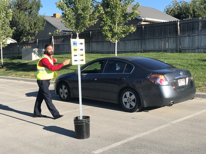 (Benjamin Wood | The Salt Lake Tribune)   Faculty members with American Preparatory Academy in Draper helped direct traffic as families arrived Monday for the first day of the 2017-2018 school year.