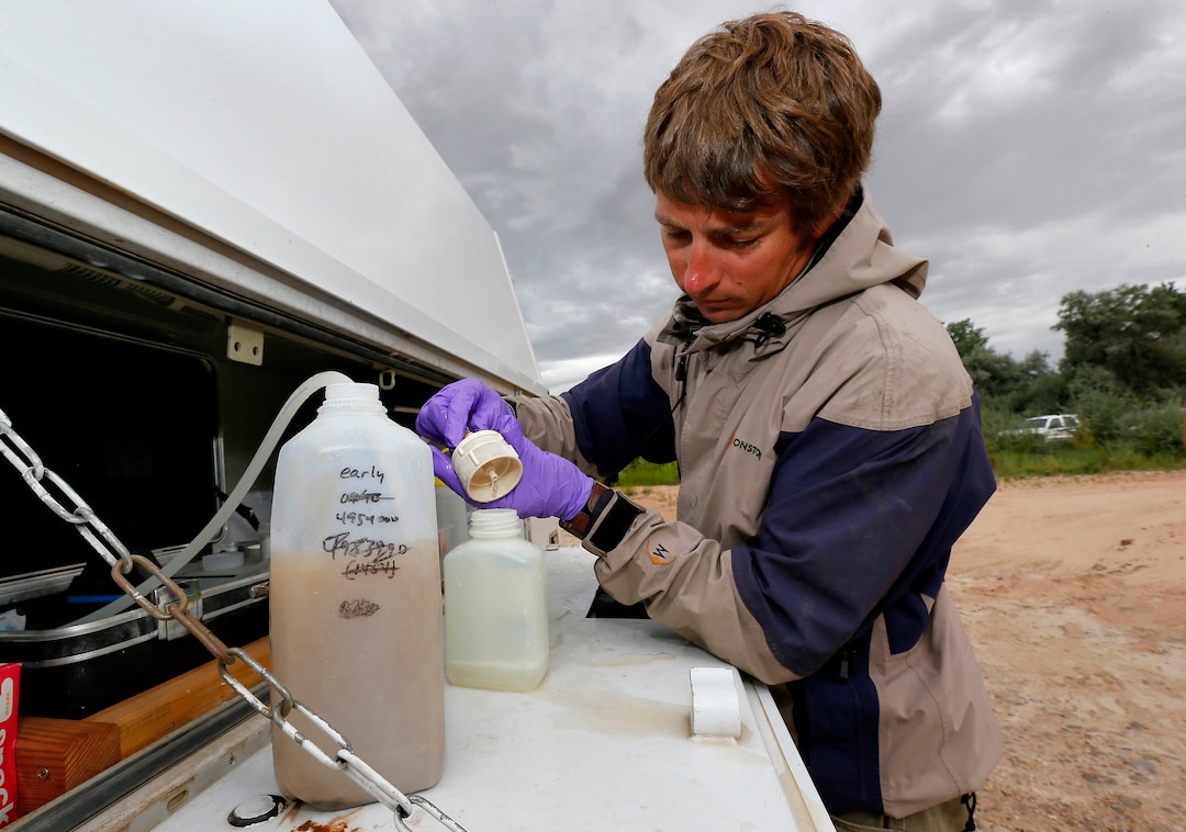 Ben Brown, with the Utah Department of Environmental Quality, filters a water sample from the San Juan River, Tuesday, Aug. 11, 2015, in Montezuma Creek, Utah. A spill containing lead and arsenic from the abandoned Gold King Mine in Silverton, Colo., leaked into the Animas River, which flows into the San Juan River in southern Utah, on Aug. 5. The spill was caused by a mining and safety team working for the EPA.  (AP Photo/Matt York) 