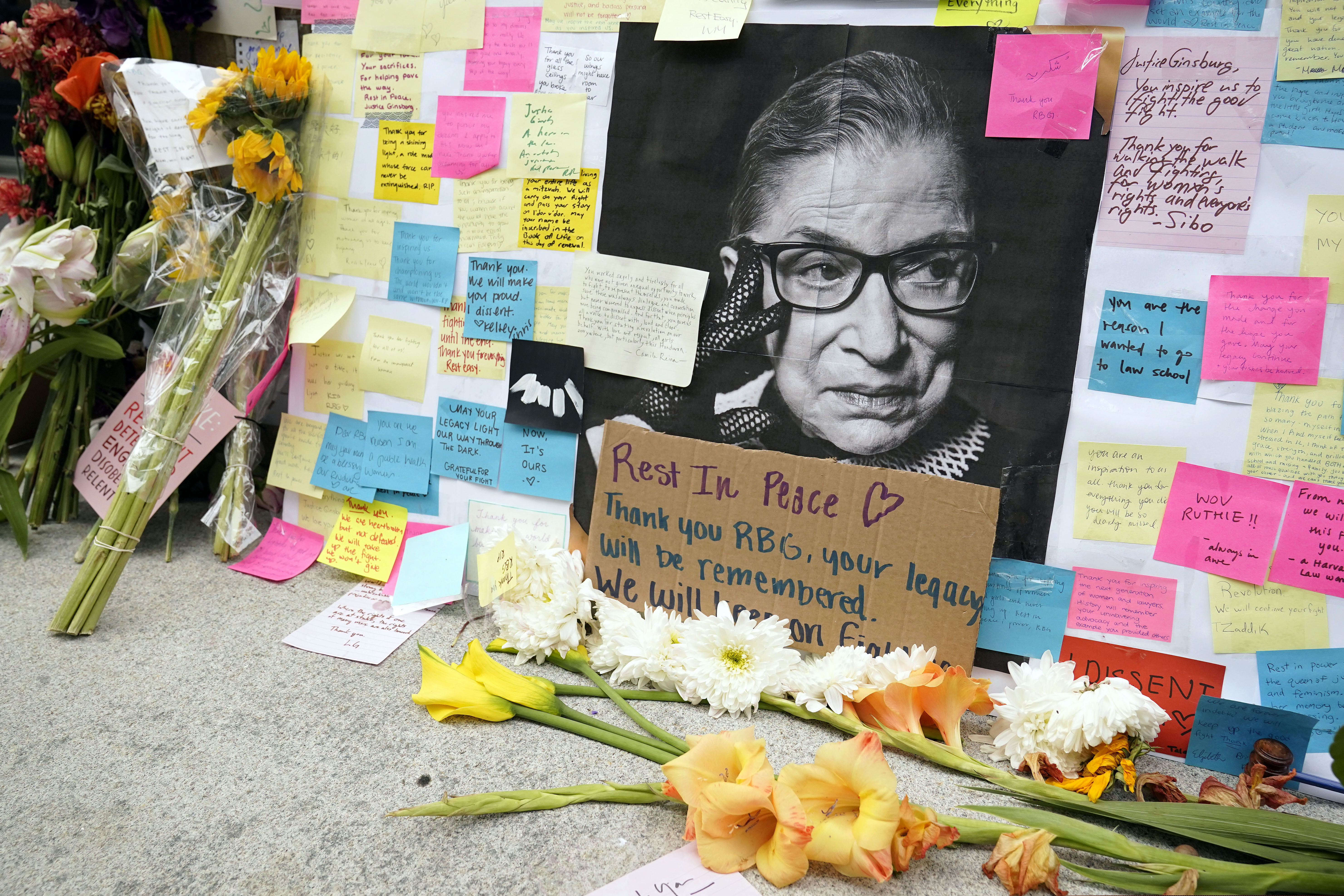 A memorial to U.S. Supreme Court Justice Ruth Bader Ginsburg includes a photograph of the late Justice, Tuesday, Sept. 22, 2020, outside the Harvard Law School library at Langdell Hall, on the campus of Harvard University, in Cambridge, Mass. Ginsburg, who attended Harvard law school but transferred to Columbia, died Friday, Sept. 18, 2020, at the age of 87. (AP Photo/Steven Senne)