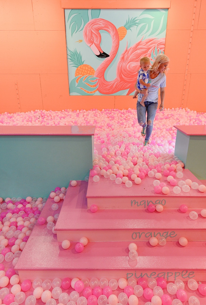 (Francisco Kjolseth  |  The Salt Lake Tribune)  Tazia Hall holds her son Brody, 1, as they step out of the "giant neon-fruit bowl" at Hall of Breakfast, a quirky new art exhibit that celebrates the first meal of the day. Each room celebrates a favorite breakfast food from eggs and bacon to cereal and coffee.