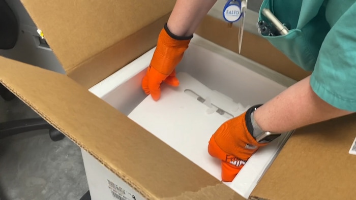 (Photos courtesy Intermountain Healthcare) An employee at Utah Valley Hospital in Provo unboxes the state of Utah's first batch of COVID-19 vaccine, on Monday, Dec. 14, 2020. The vaccine, developed by Pfizer Inc. and BioNTech, must be stored at around 95 degrees below zero Fahrenheit, so it is shipped surrounded by dry ice and stored in a supercold freezer.