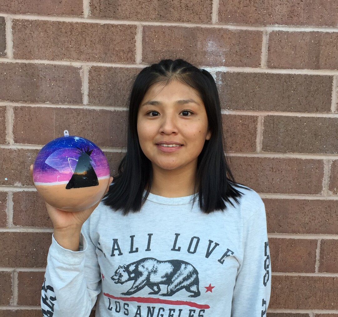 (Photo courtesy of Georgiana Simpson) A student at Whitehorse High School holds an ornament she painted.