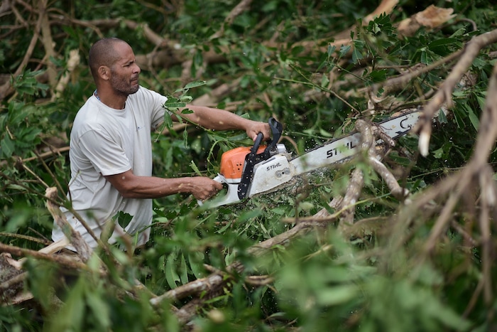 A municipal government worker clears a road after the passing of Hurricane Maria, in Yabucoa, Puerto Rico, Thursday, September 21, 2017. As of Thursday evening, Maria was moving off the northern coast of the Dominican Republic with winds of 120 mph (195 kph). The storm was expected to approach the Turks and Caicos Islands and the Bahamas late Thursday and early Friday. (AP Photo/Carlos Giusti)