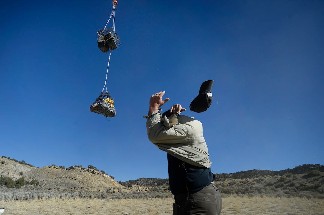 (Scott Sommerdorf   |  The Salt Lake Tribune)   
Paleontologist Tylor Birthisel, loses his hat as the helicopter carrying one of the loads of fossilized Tyrannosaurus Rex skeleton found near Tropic, Utah, comes in to be unloaded, Sunday, October 15, 2017.
