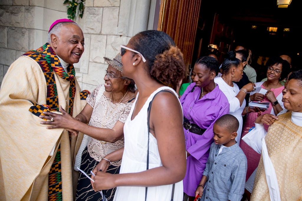 (Andrew Harnik | AP file photo) In this Sunday, June 2, 2019, file photo, Archbishop of Washington Wilton Gregory, left, greets parishioners after Mass at St. Augustine Church in Washington. In June 2020, Gregory, the first African American in charge of the Archdiocese of Washington, joined with eight fellow bishops from his region to acknowledge the church’s “sins and failings” in regard to racial justice. “Prayer and dialogue, alone, are not enough. We must act to bring about true change,” the bishops said, calling for more racial equality in health care, education, housing and criminal justice.