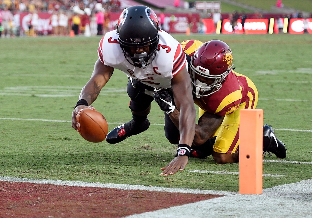 Utah quarterback Troy Williams, left, scores a touchdown while Southern California cornerback Jack Jones attempts a tackle during the first half of an NCAA college football game in Los Angeles, Saturday, Oct. 14, 2017. (AP Photo/Kelvin Kuo)
