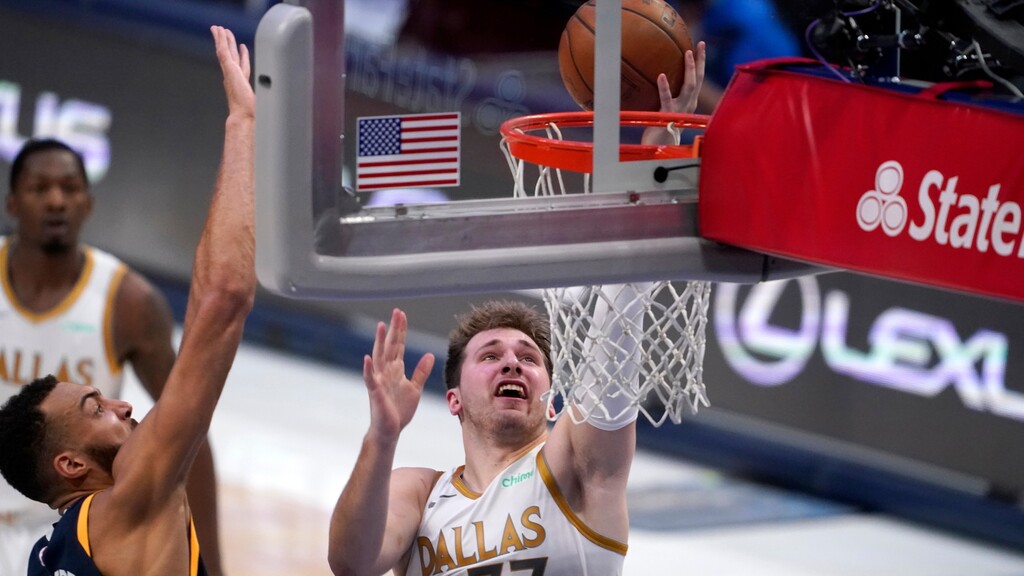 Utah Jazz center Rudy Gobert, left, defends against a shot by Dallas Mavericks guard Luka Doncic (77) in the second half of an NBA basketball game in Dallas, Monday April 5, 2021. (AP Photo/Tony Gutierrez)