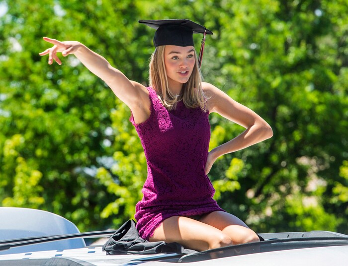 (Rick Egan | The Salt Lake Tribune) Liv Scott dances to the music as she rides in the parade of 2020 graduates drive by in a “drive through” graduation ceremony at Alta High, Thursday, May 28, 2020.
.