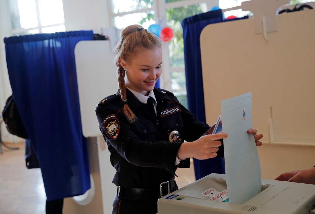 A police cadet casts her vote in the presidential election in Moscow, Russia, Sunday, March 18, 2018. Russians are voting in a presidential election in which Vladimir Putin is seeking a fourth term in the Kremlin. (AP Photo/Pavel Golovkin)