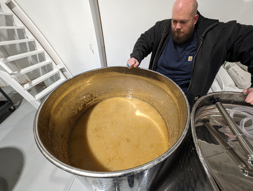 (Short Creek Spirits) Ray Hammon examines a fermenting tank at Short Creek Spirits in Colorado City, Ariz.