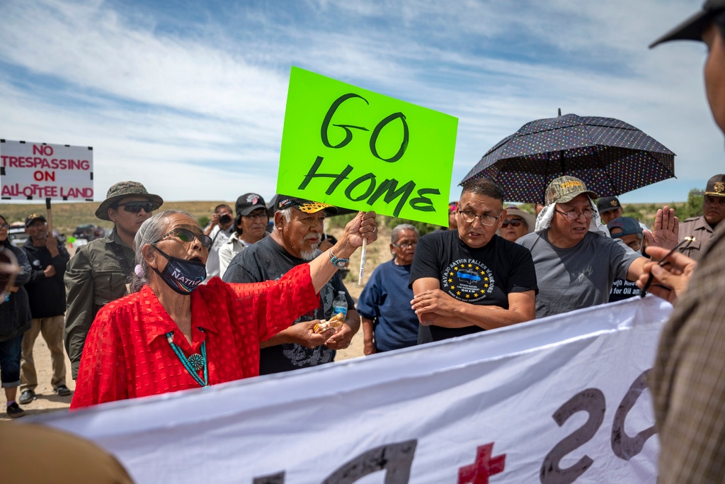 (Jon Austria | The Albuquerque Journal via AP) Landowner Paulina Atenico, left, tell activists to "go home" near a road block on County Road 7950 east of Chaco Culture National Park on Sunday, June 11, 2023. Opponents and supporters for a buffer zone around Chaco Culture National Park clashed on Sunday after Navajo Allotees blocked a portion of CR 7950 that lead in to the park during U.S. Interior Secretary Deb Haaland's planed visit.