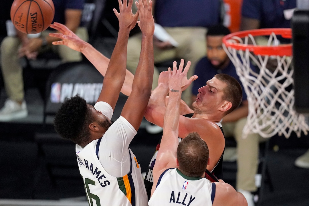 Utah Jazz's Juwan Morgan, left, and Joe Ingles (2) defend as Denver Nuggets' Nikola Jokic (15) makes a pass during the first half an NBA first round playoff basketball game, Tuesday, Sept. 1,2020, in Lake Buena Vista, Fla. (AP Photo/Mark J. Terrill)