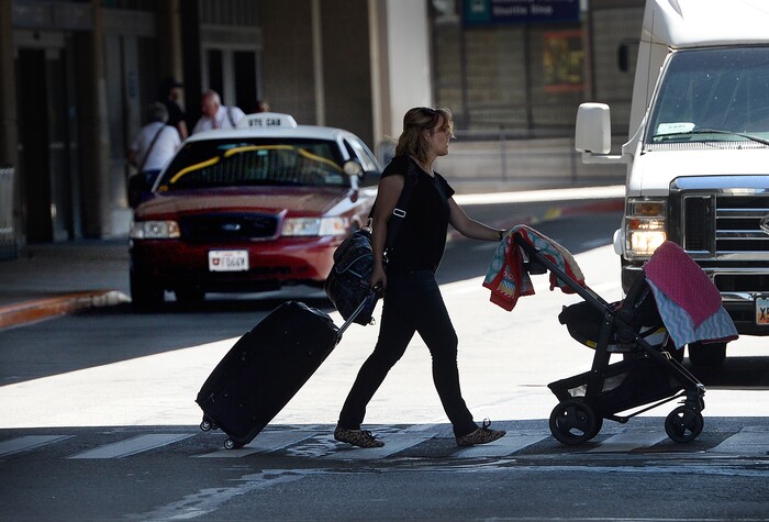 Scott Sommerdorf   |  The Salt Lake Tribune  A traveler walks past a taxi dropping off a passenger at the Salt Lake International Airport, Wednesday, July 20, 2016.  There have been some complaints from airport visitors about largely unregulated taxi fares. Cabs no longer need to have meters, can largely charge any fare they want (with some exceptions in SLC itself), and need not tell passengers in advance how much they will charge.