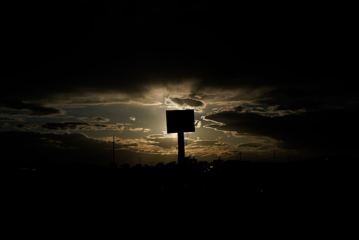 The sun sets behind a basketball hoop and backboard at Dinehdeal family compound in Tuba City, Ariz., on the Navajo reservation on April 20, 2020. The reservation has some of the highest rates of coronavirus in the country. If Navajos are susceptible to the virus' spread in part because they are so closely knit, that's also how many believe they will beat it. (AP Photo/Carolyn Kaster)