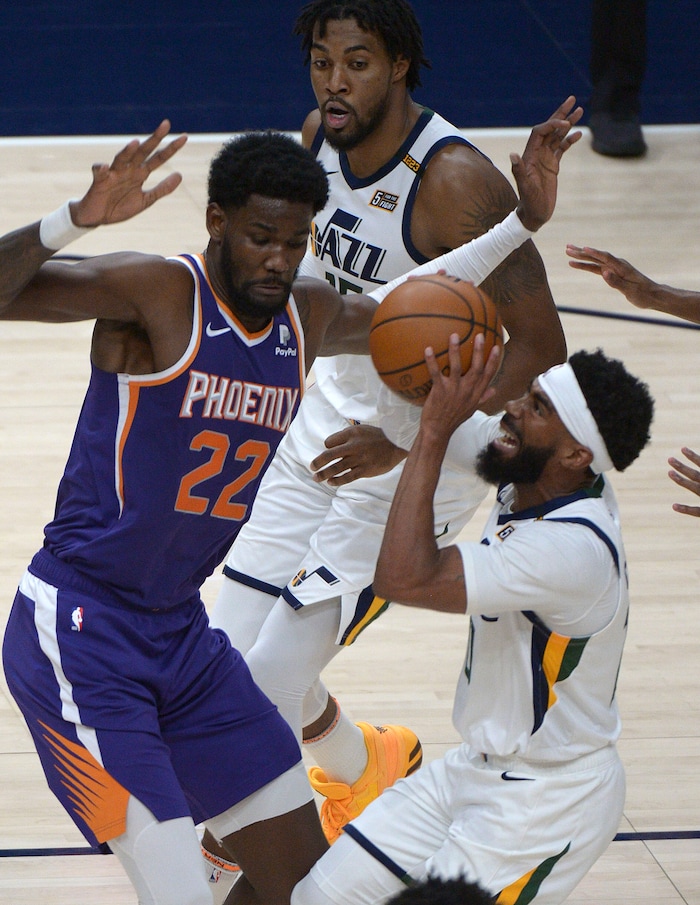 (Leah Hogsten | The Salt Lake Tribune) Utah Jazz guard Mike Conley (10) drives past Phoenix Suns center Deandre Ayton (22) as the Jazz crack open their 2020-21 preseason with their second game against the Phoenix Suns, Dec. 14, 2020.