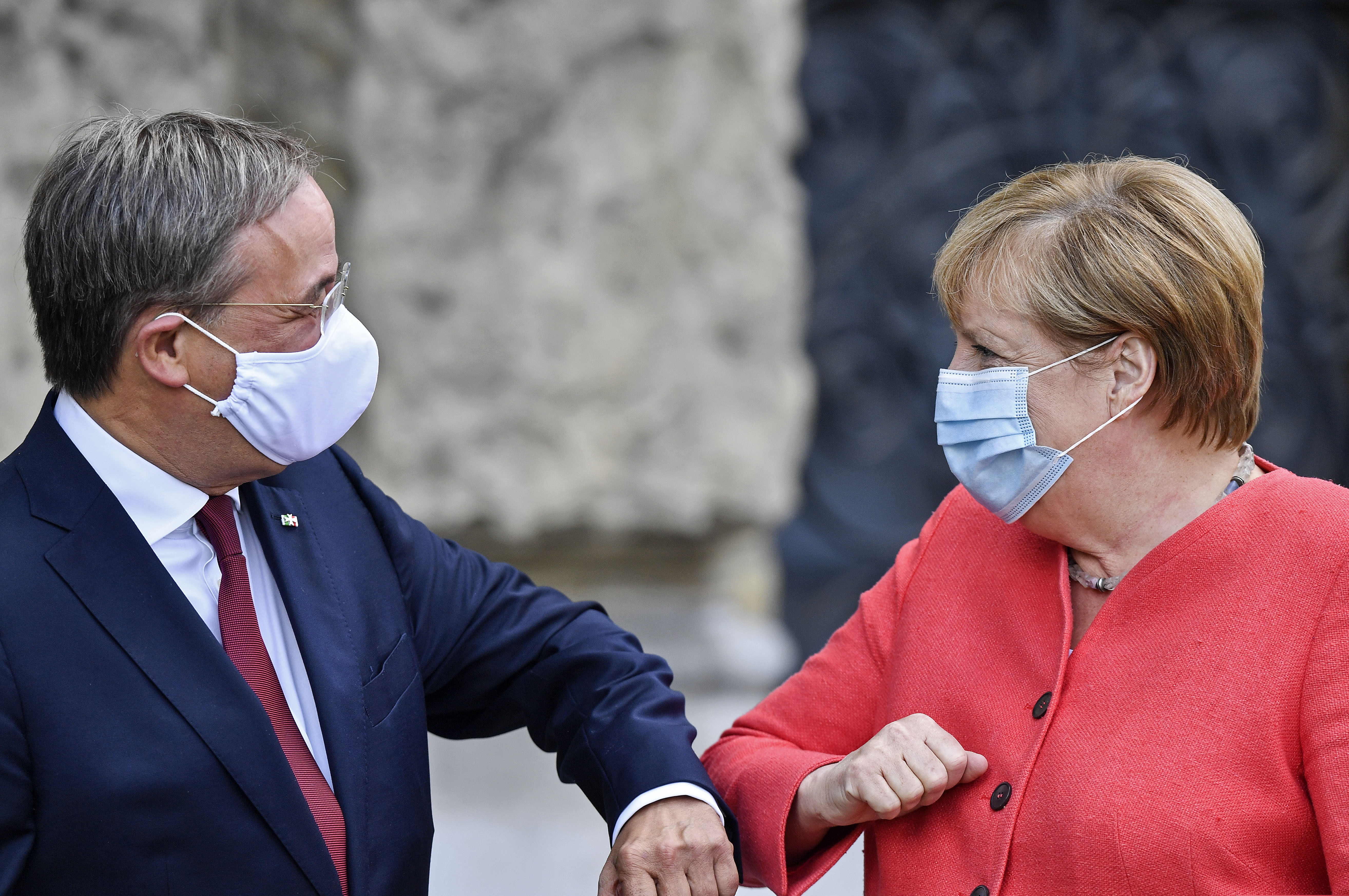 (Martin Meissner | AP file photo)  German chancellor Angela Merkel, right, wears a face mask due to the coronavirus pandemic as she meets Governor Armin Laschet, left, during her visit at Germany's most populated federal state North Rhine-Westphalia in Duesseldorf, Germany, Tuesday, Aug. 18, 2020.