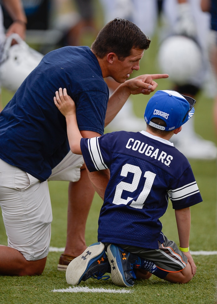 (Francisco Kjolseth  |  The Salt Lake Tribune)  Jed Beck of Alpine is joined by his son Jake, 9, as they get a close look at the action from the sideline as BYU holds a scrimmage at LaVell Edwards Stadium in Provo on Thursday, Aug. 10, 2017.