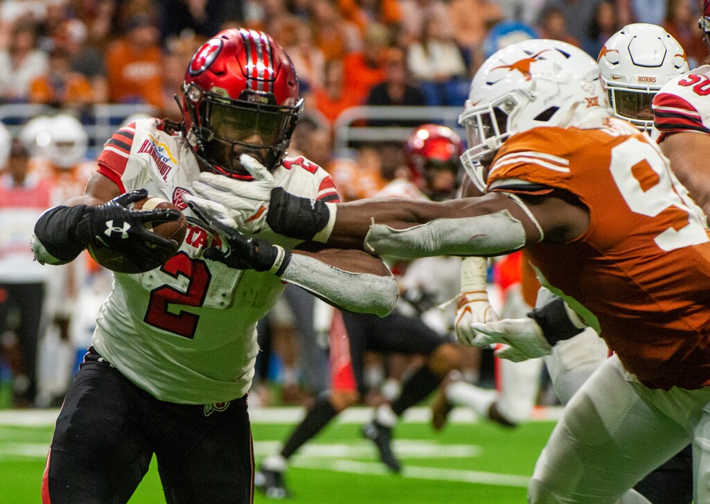 (Rick Egan  |  The Salt Lake Tribune)  Utah Utes running back Zack Moss (2) is stopped by Texas Longhorns defensive lineman Moro Ojomo (98), in Alamo Bowl football action, between the Utes and the Texas Longhorns, in San Antonio, Tuesday, Dec. 31, 2019.