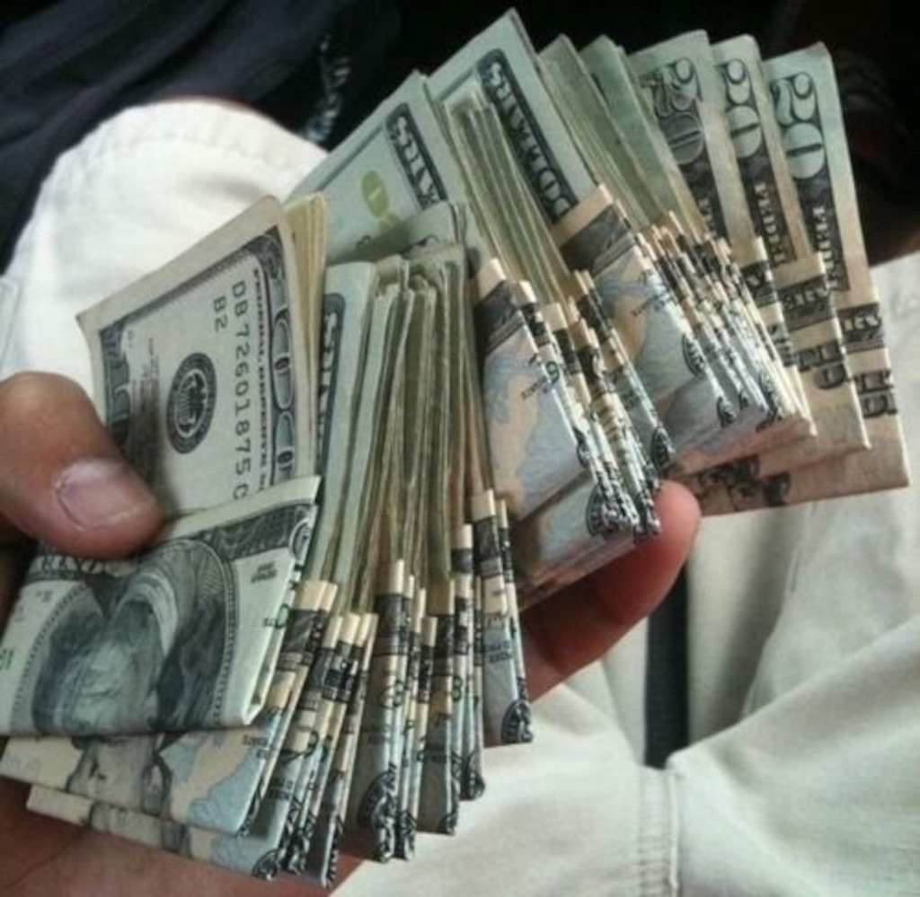 (Getty Images) Holding a Stack of Money