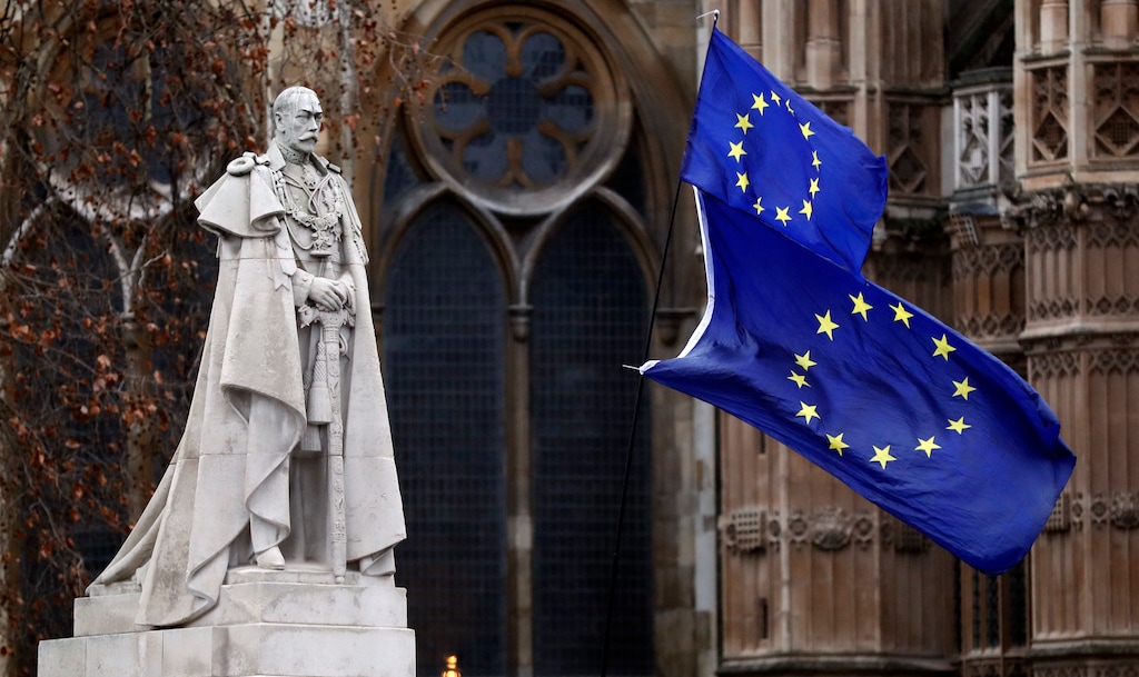 The EU flags wave next to the statue of King George V in Westminster, London, Wednesday, Jan. 16, 2019. British lawmakers overwhelmingly rejected Prime Minister Theresa May's divorce deal with the European Union on Tuesday, plunging the Brexit process into chaos and triggering a no-confidence vote Wednesday that failed to topple her government. (AP Photo/Frank Augstein)