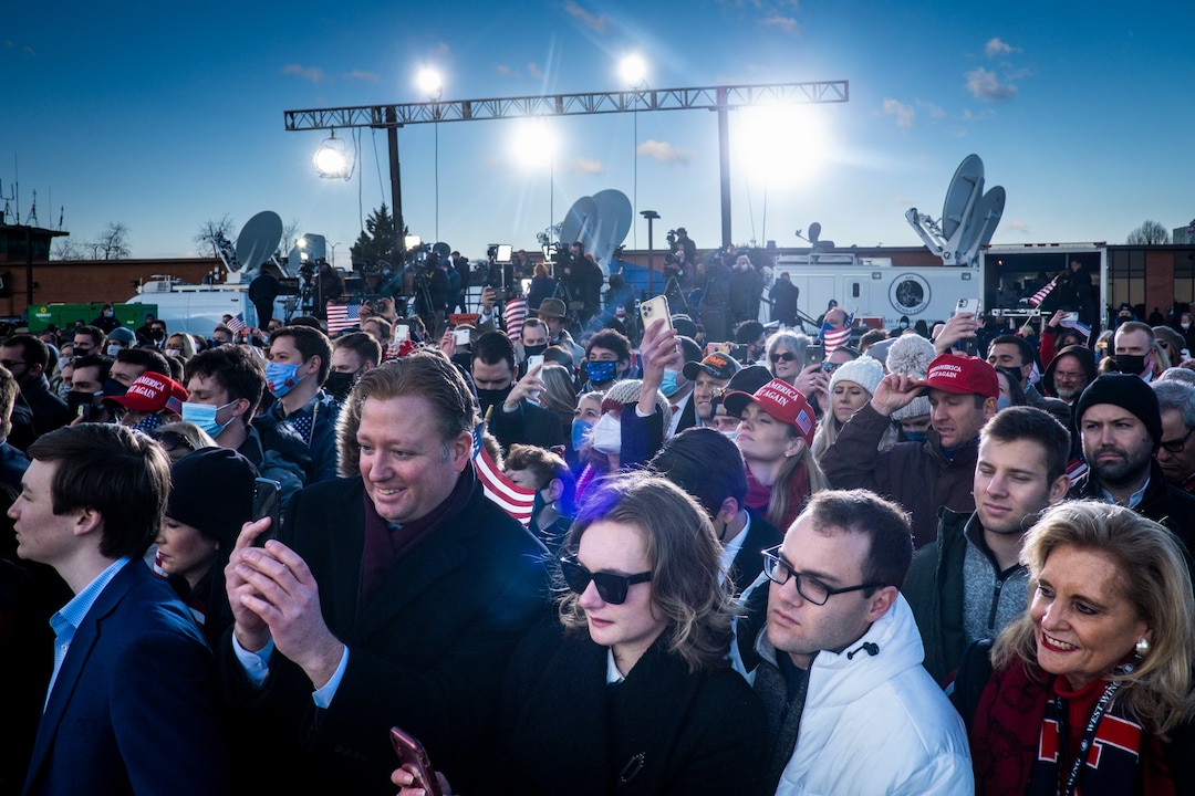 Supporters listen as President Donald Trump speaks before boarding Air Force One for his last time as president at Joint Base Andrews in Maryland, Jan. 20, 2021. Defeated and twice impeached, the 45th president used his farewell remarks before a sparse crowd to brag about his record and wish luck to the incoming administration. (Pete Marovich/The New York Times)
