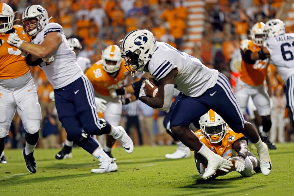 Brigham Young running back Ty'Son Williams (5) escapes the grasp of Tennessee linebacker Will Ignont (23) to score a touchdown on a 5-yard run to give his team a 29-26 win in overtime an NCAA college football game against Tennessee Saturday, Sept. 7, 2019, in Knoxville, Tenn. (AP Photo/Wade Payne)