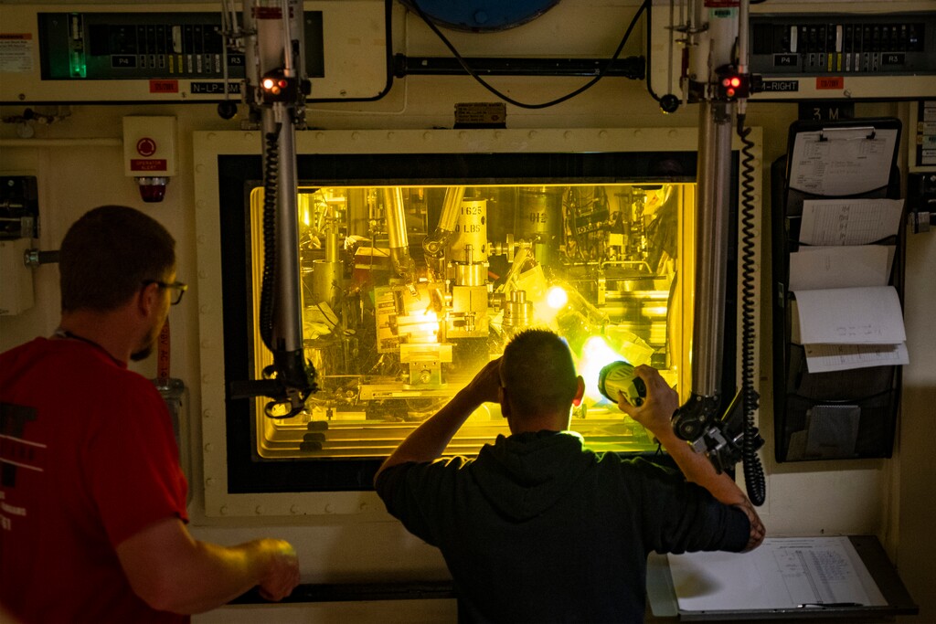(Rick Egan | The Salt Lake Tribune) Workers examine irradiated material through four-foot thick glass windows at the Hot Fuel Examination Facility at the Idaho National Laboratory, on Tuesday, Sept. 23, 2025. Robotic arms help workers move and manipulate the objects.