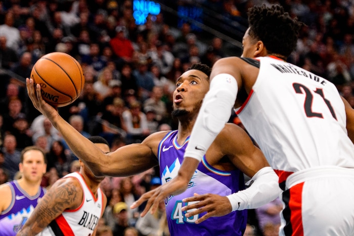 (Trent Nelson  |  The Salt Lake Tribune) Utah Jazz guard Donovan Mitchell (45) looks to shoot, defended by Portland Trail Blazers center Hassan Whiteside (21) as the Utah Jazz host the Portland Trail Blazers, NBA basketball in Salt Lake City on Thursday, Dec. 26, 2019.
